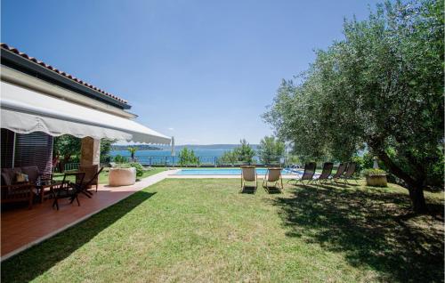 a group of chairs sitting on a lawn next to a pool at Pet Friendly Home In Portoroz With Wifi in Portorož