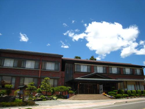 a red brick building with a blue sky and clouds at Taiheikan in Fujikawaguchiko