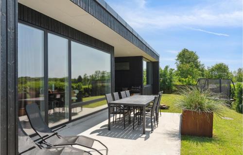 a patio with a table and chairs on the side of a house at 3 Bedroom Cozy Home In Børkop in Børkop