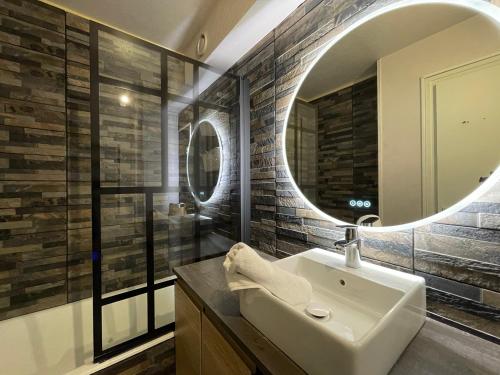 une salle de bain avec un lavabo et un miroir dans l'établissement Homency - Résidence Le Commodore 223, à L'Alpe-d'Huez