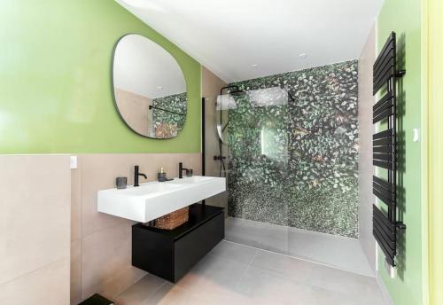 une salle de bain avec un lavabo blanc et un miroir dans l'établissement Villa Balandra Goyrans -Toulouse, à Goyrans