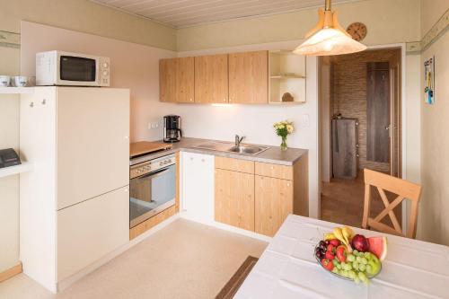 a kitchen with a table with a bowl of fruit on it at Gästehaus Nöchel in Reinhardshausen