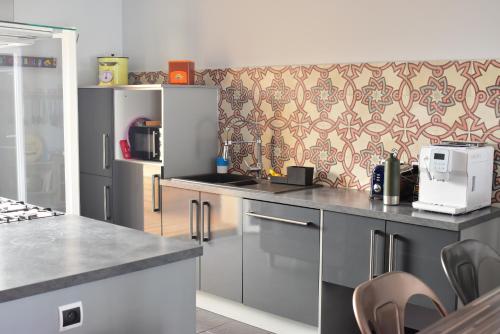 - une cuisine avec un comptoir et une cafetière dans l'établissement Maison de village avec sa charmante petite cour intérieure, à Fleury