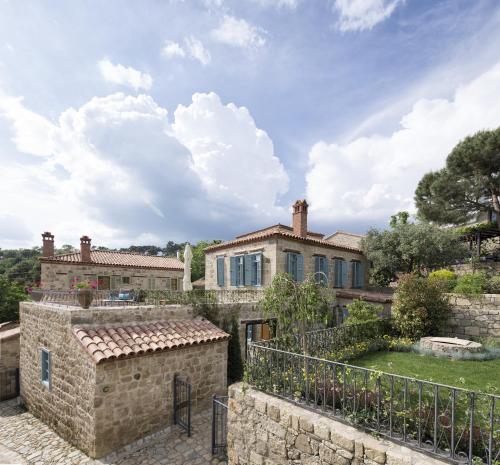 an exterior view of a stone house with a fence at İda Blue Adatepe in Kucukkuyu