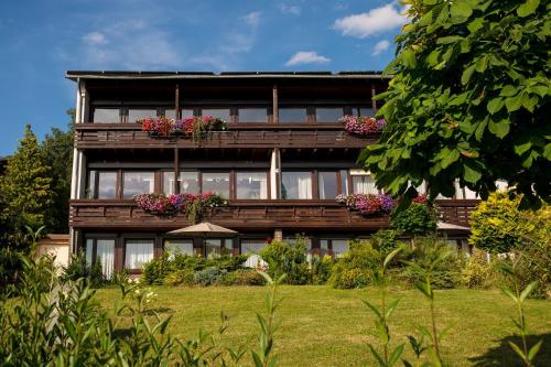a house with flower boxes on the balcony at Gästehaus Nöchel in Reinhardshausen