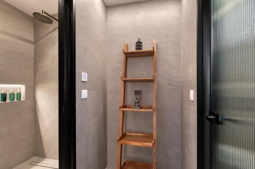 a bathroom with a wooden shelf next to a door at Elia Mykonos Resort in Elia Beach