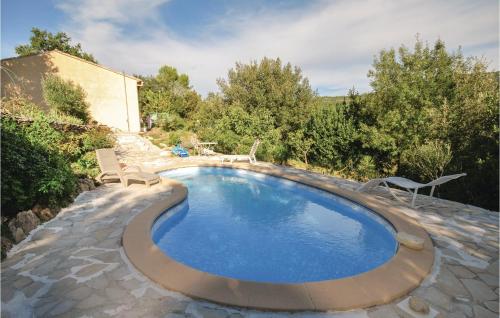 une piscine avec deux chaises et une maison dans l'établissement Lovely Home In St Anastasie S Issoles, à Forcalqueiret