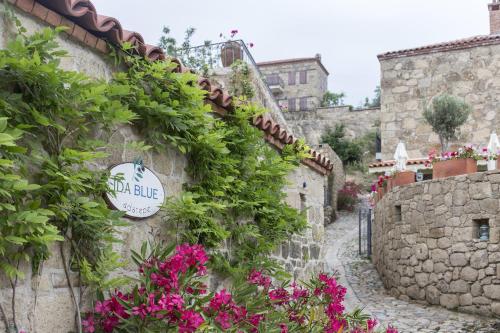a street in a village with flowers at İda Blue Adatepe in Kucukkuyu