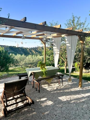 a table and a chair under a pergola at Relaxing farmhouse in San Marino