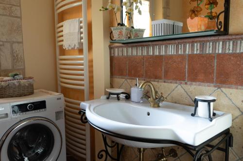 a bathroom with a sink and a washing machine at Relaxing farmhouse in San Marino