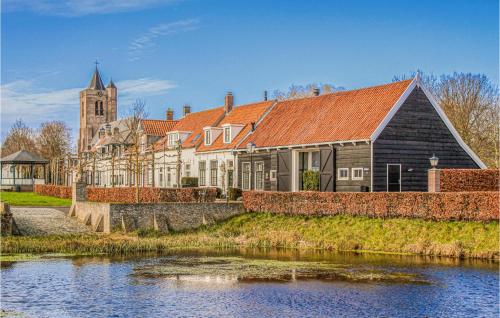 a large house next to a river with a church at Awesome Home In Heinkenszand With Wifi in Heinkensand