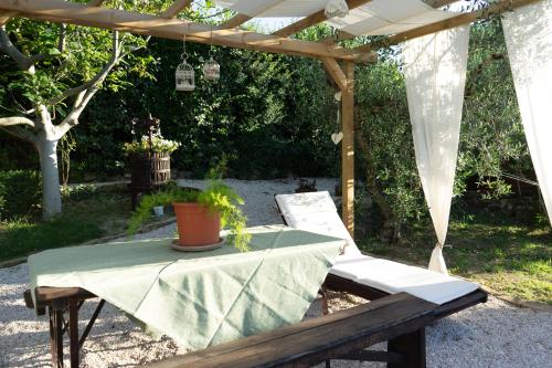 a table and a chair under a pergola at Relaxing farmhouse in San Marino