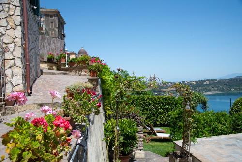 a balcony with flowers and a view of the water at Giardino sul Lago SPA Jacuzzi in Castel Gandolfo