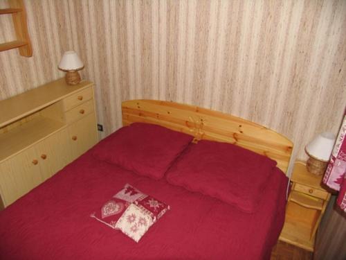 - une chambre avec un lit rouge et 2 oreillers dans l'établissement Appartement cosy, 5 pers., balcon sud, à 200m des remontées du Linga, Châtel - FR-1-676-159, à Châtel