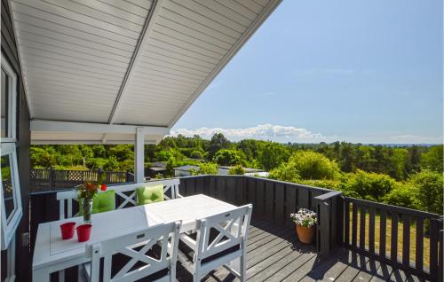 a patio with a white table and chairs on a deck at Stunning Home In Sjællands Odde in Yderby