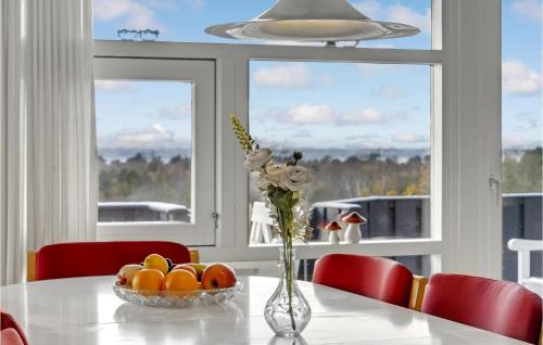 a table with a vase with flowers and fruit on it at Stunning Home In Sjællands Odde in Yderby