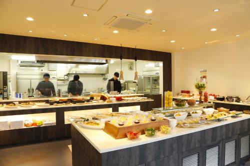 a large kitchen with people standing in the kitchen at Hotel Sunshine Tokushima in Tokushima