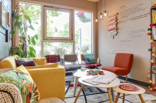 - un salon avec des chaises colorées et une table dans l'établissement Brit Hotel Saint-Nazaire Centre, à Saint-Nazaire