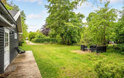 a backyard with black chairs and a wooden deck at 3 Bedroom Amazing Home In Glesborg in Glesborg