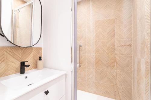 une salle de bain avec un lavabo blanc et un miroir dans l'établissement Le cosy - Loft sublime Plein centre de Douai, à Douai