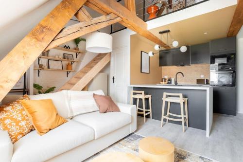 un salon avec un canapé blanc et une cuisine dans l'établissement Le cosy - Loft sublime Plein centre de Douai, à Douai