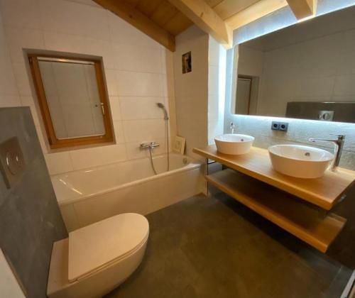 La salle de bains est pourvue de 2 lavabos, de toilettes et d'une baignoire. dans l'établissement Schöneben Chalet Waldblick, à Wald im Pinzgau