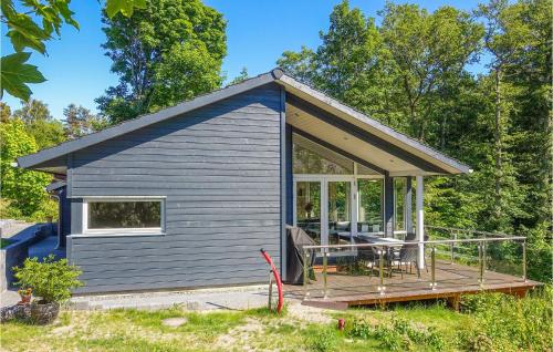 a small blue house with a porch and a deck at Stunning Home In Rønne With Wifi in Rønne