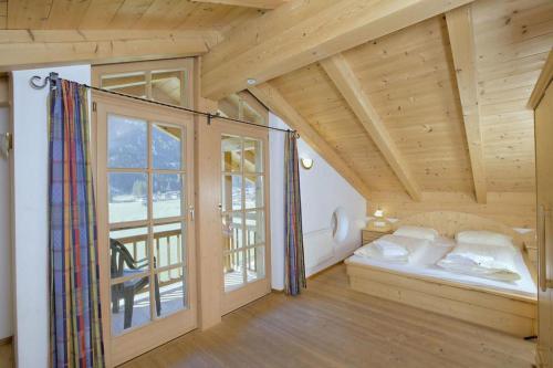 a room with a bed and a large window at Schöneben Chalet 4-Jahreszeiten in Wald im Pinzgau