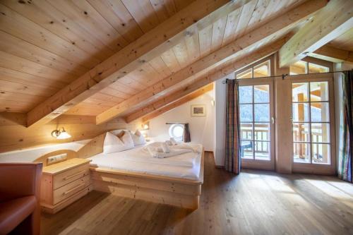 un lit dans une chambre avec un plafond en bois dans l'établissement Schöneben Chalet Vienna, à Wald im Pinzgau