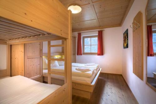 une chambre avec deux lits superposés et une fenêtre dans l'établissement Schöneben Chalet Hohe Schwalbe, à Wald im Pinzgau