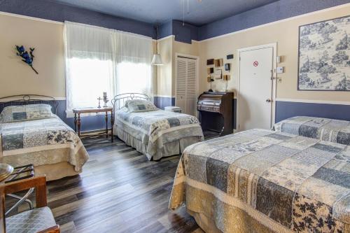 a hotel room with two beds and a window at Auberge Presbytere Mont Lac-Vert in Hébertville