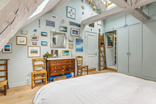 - une chambre avec un lit, une commode et des chaises dans l'établissement Cosy apartment Place des Vosges, à Paris