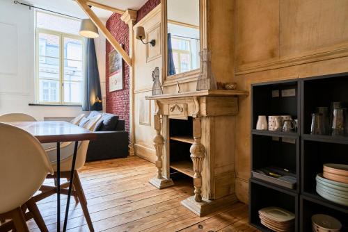 a living room with a fireplace and a table at Old Lille charming duplex apartment in Lille