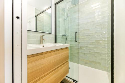 a bathroom with a sink and a glass shower at Homency - Résidence de l'Alpe 19 in L'Alpe-d'Huez