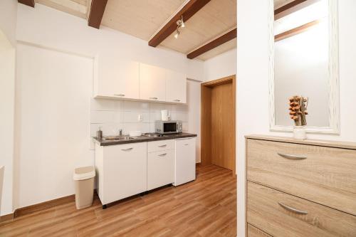 a kitchen with white cabinets and a counter top at Apartments Feliks in Ljubač