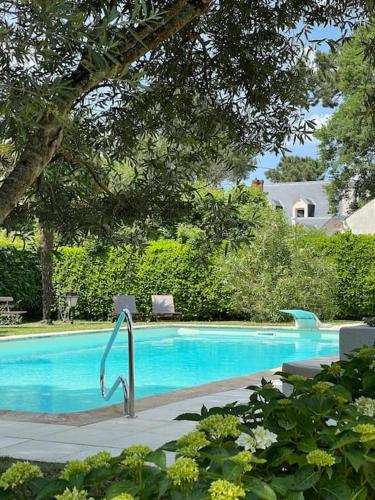 - une piscine dans une cour avec des arbres et des buissons dans l'établissement Villa avec piscine Domaine des Fées à 100 m plage, à Vaux-sur-Mer