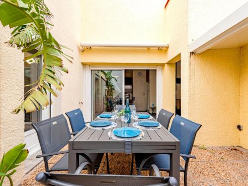 une table en bois recouverte de plaques bleues dans l'établissement Apartment Zodiaques 2-5 by Interhome, au Barcarès