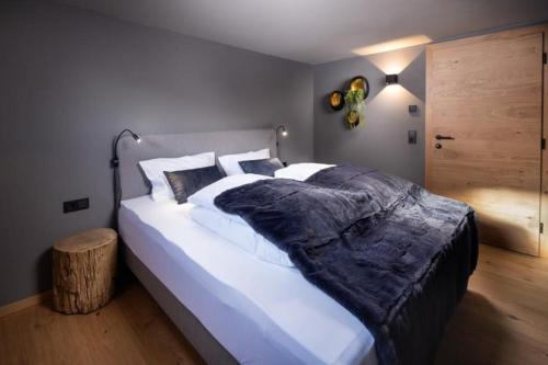 - une chambre avec un grand lit blanc et du parquet dans l'établissement Schöneben Appartementen Top 1, à Wald im Pinzgau