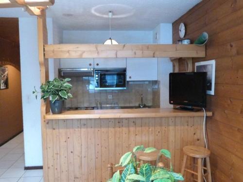 Il comprend une cuisine avec un comptoir, un four micro-ondes et une télévision. dans l'établissement Appartement cosy 4 pers. à Châtel, balcon exposé sud, proche télécabine Linga, WiFi inclus - FR-1-676-125, à Châtel