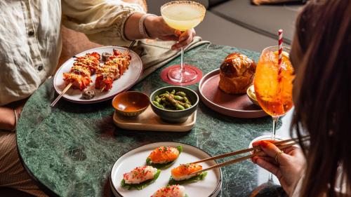 a table topped with plates of food and drinks at Hotel Indigo Sydney Potts Point by IHG in Sydney
