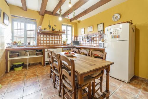 a kitchen with a wooden table and a white refrigerator at Laguna Herrera in Campo de Cuéllar
