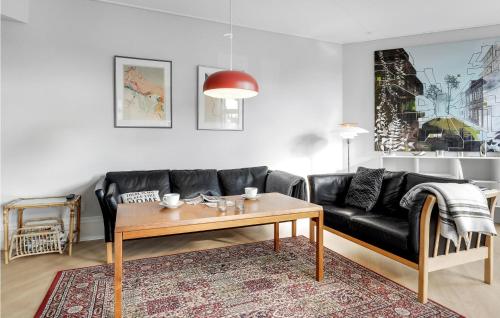 a living room with a black couch and a table at Cozy Apartment In Svaneke With Wifi in Svaneke