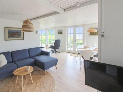 a living room with a blue couch and a tv at Holiday Home Fabine - 50m from the sea by Interhome in Allinge