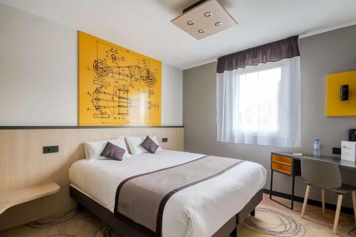 une chambre d'hôtel avec un lit et un bureau avec un bureau dans l'établissement Brit Hotel Le Cottage Le Mans Sud, à Arnage