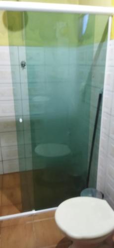 a bathroom with a toilet and a glass shower at Casa Cláudio e Rosa in Lima Duarte