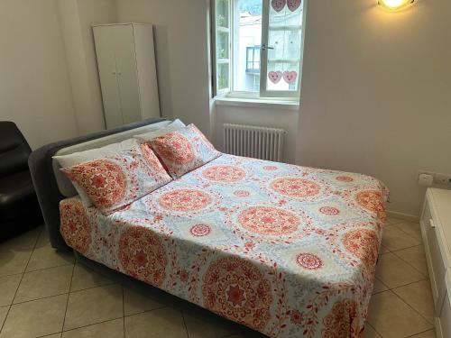 a bed with a blanket on it in a bedroom at Val di Non Apartment in Cles
