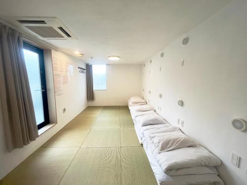 a room with a row of pillows on the wall at Hananosato Hotel 池袋本店 in Tokyo