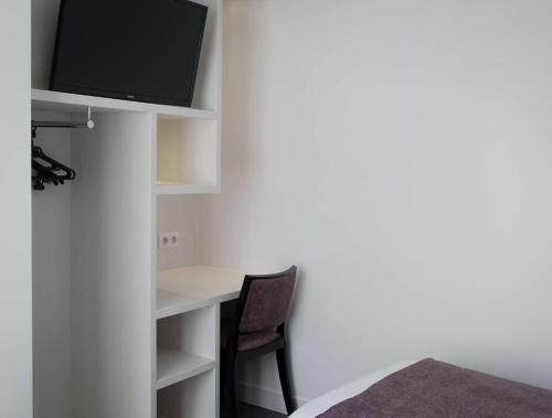 TV a/nebo společenská místnost v ubytování Brit Hotel de Grignan Vichy