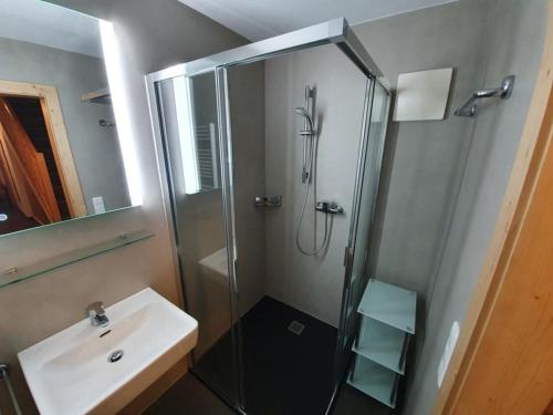 une salle de bain avec une douche en verre et un lavabo dans l'établissement Schöneben Traumhütte, à Wald im Pinzgau