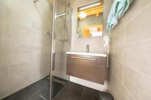 une salle de bain avec lavabo et douche dans l'établissement Schöneben Chalet Schiffer, à Wald im Pinzgau